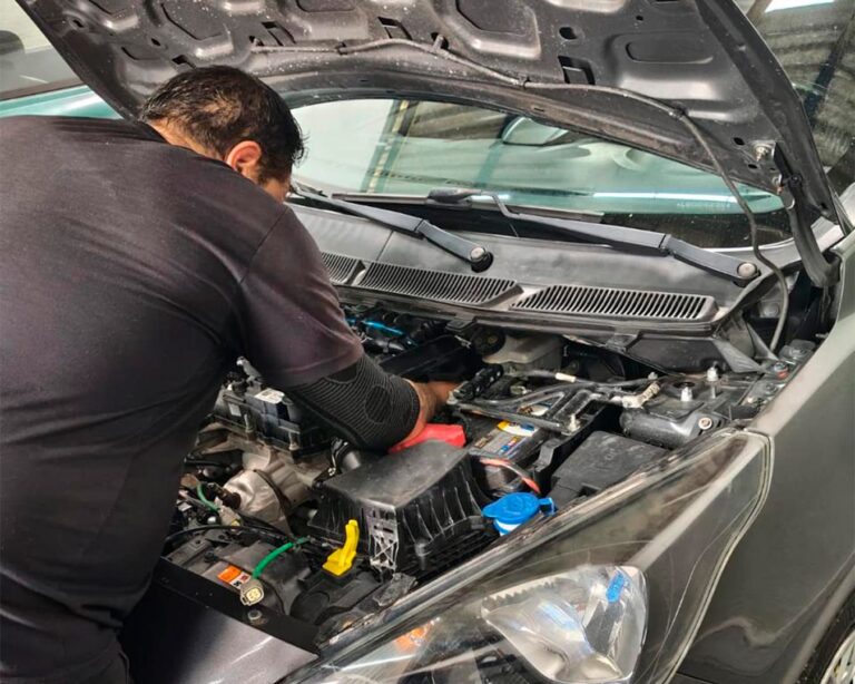 Mecânico da Mecânica Du Léo trabalhando no motor de um carro
